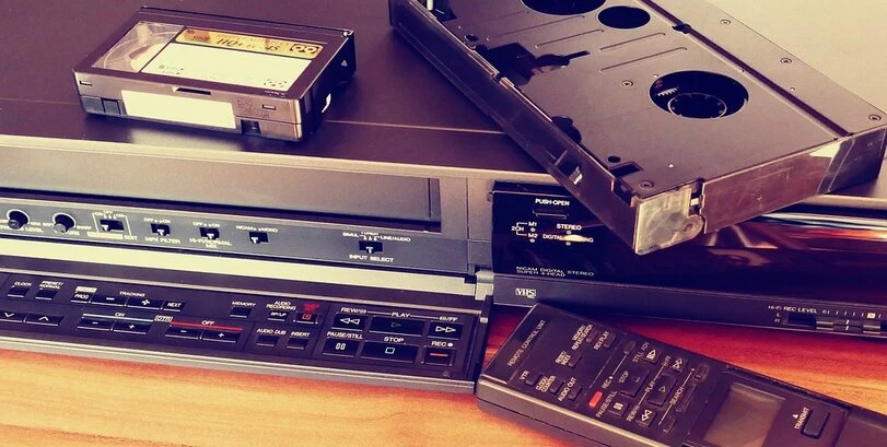 Image of a video player, remote control, and video tapes.