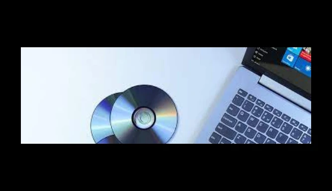 Image of two DVDs and a laptop on a white background.
