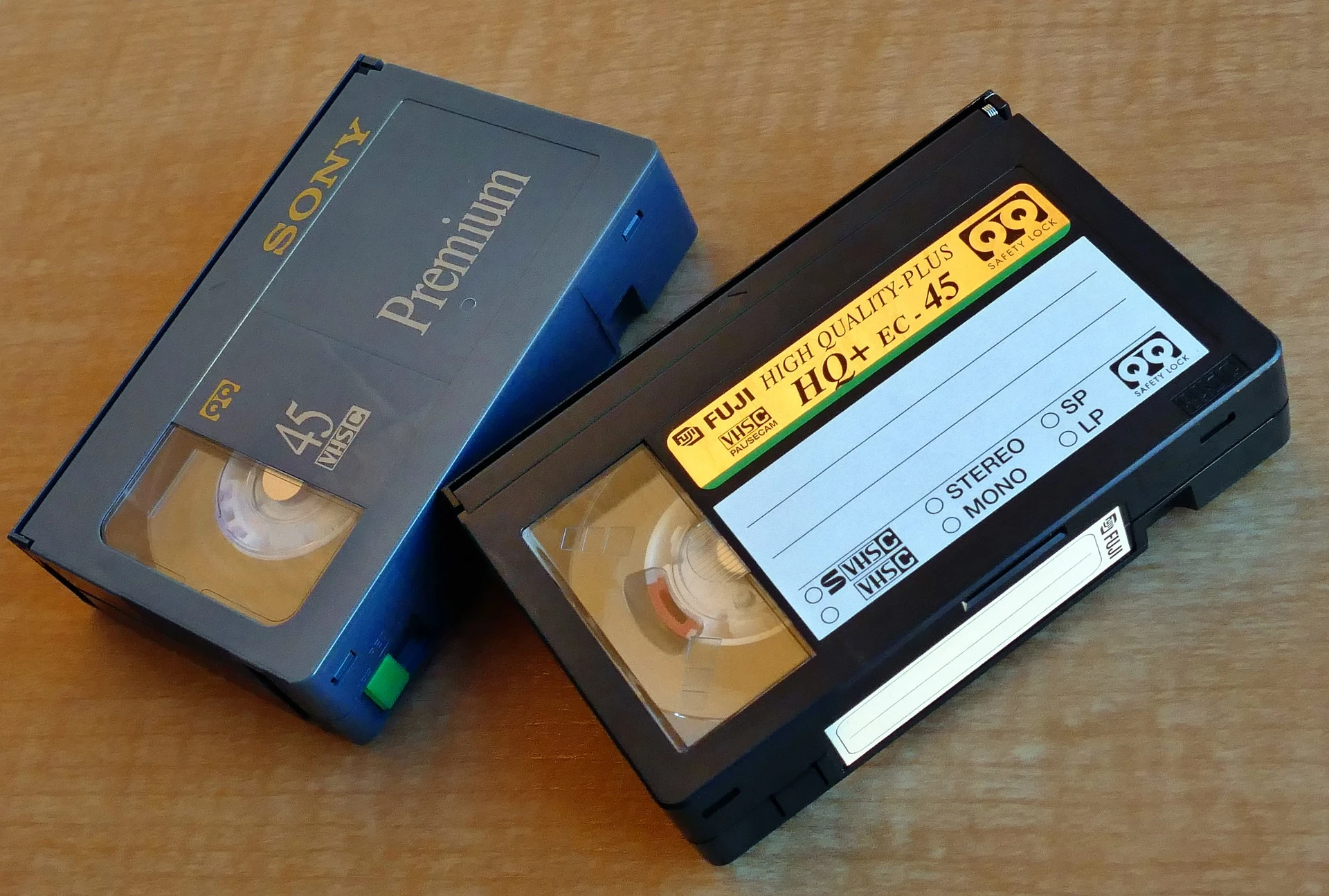 An image of two VHS C tapes on a wooden table.