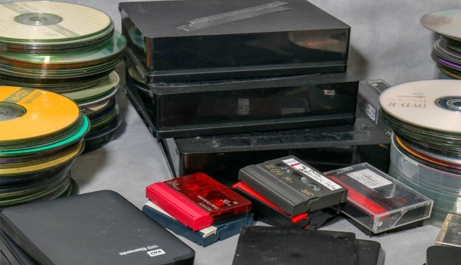 Image of CDs, DVDs, Videotapes, and hard drives.