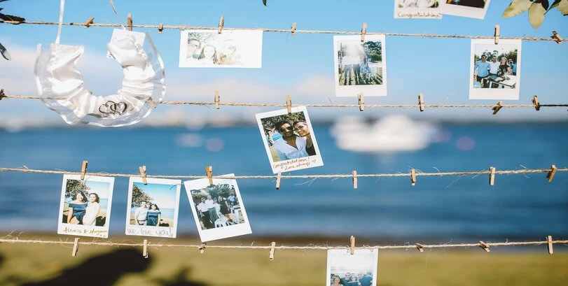 An image of hanging photos with a seaside background.
