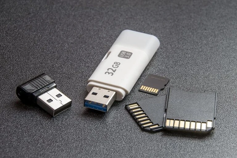Images of a USB stick, a USB dongle, and different sizes of SD cards on a black background